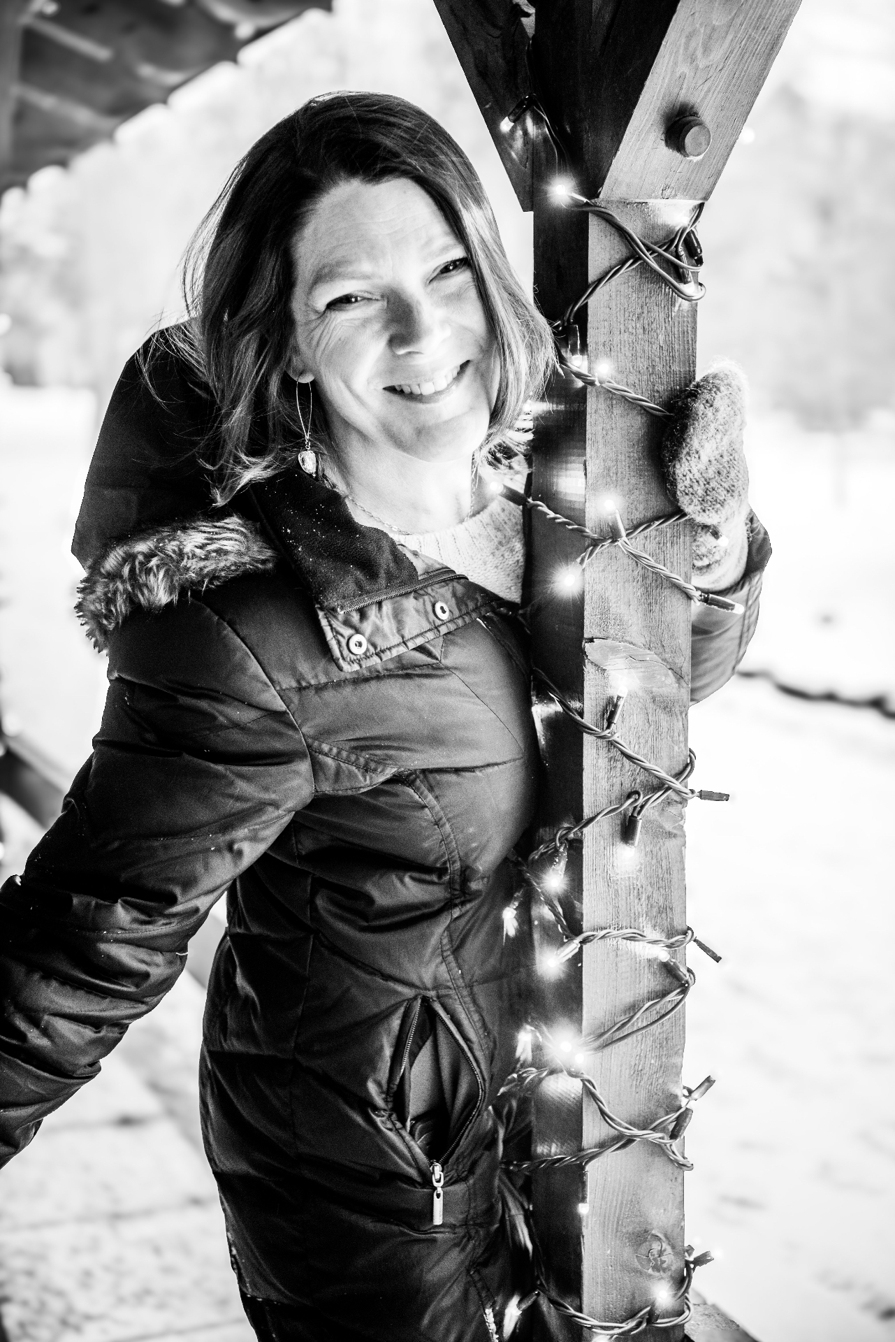Sabina Goranova, founder of Cultivate & Connect, smiling beside a wooden post wrapped in fairy lights